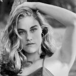 Elegant black and white portrait of a young woman in a natural setting.